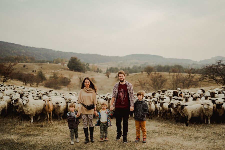 Fotografie de familie cu oi în spate pe deal