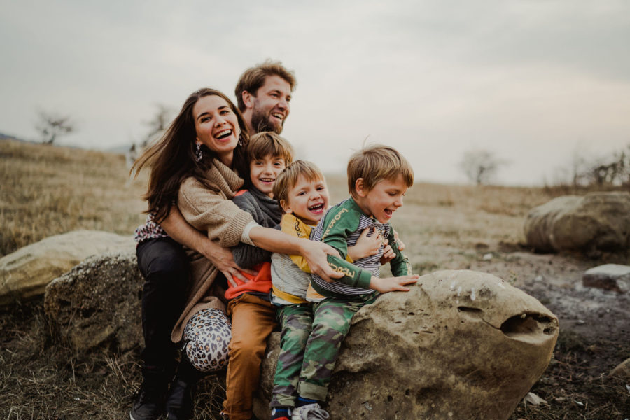 Mama și familia pe o buturugă cu copiii gemeni și băiatul mare se distrează se joacă râd tare.Fotografie de familie